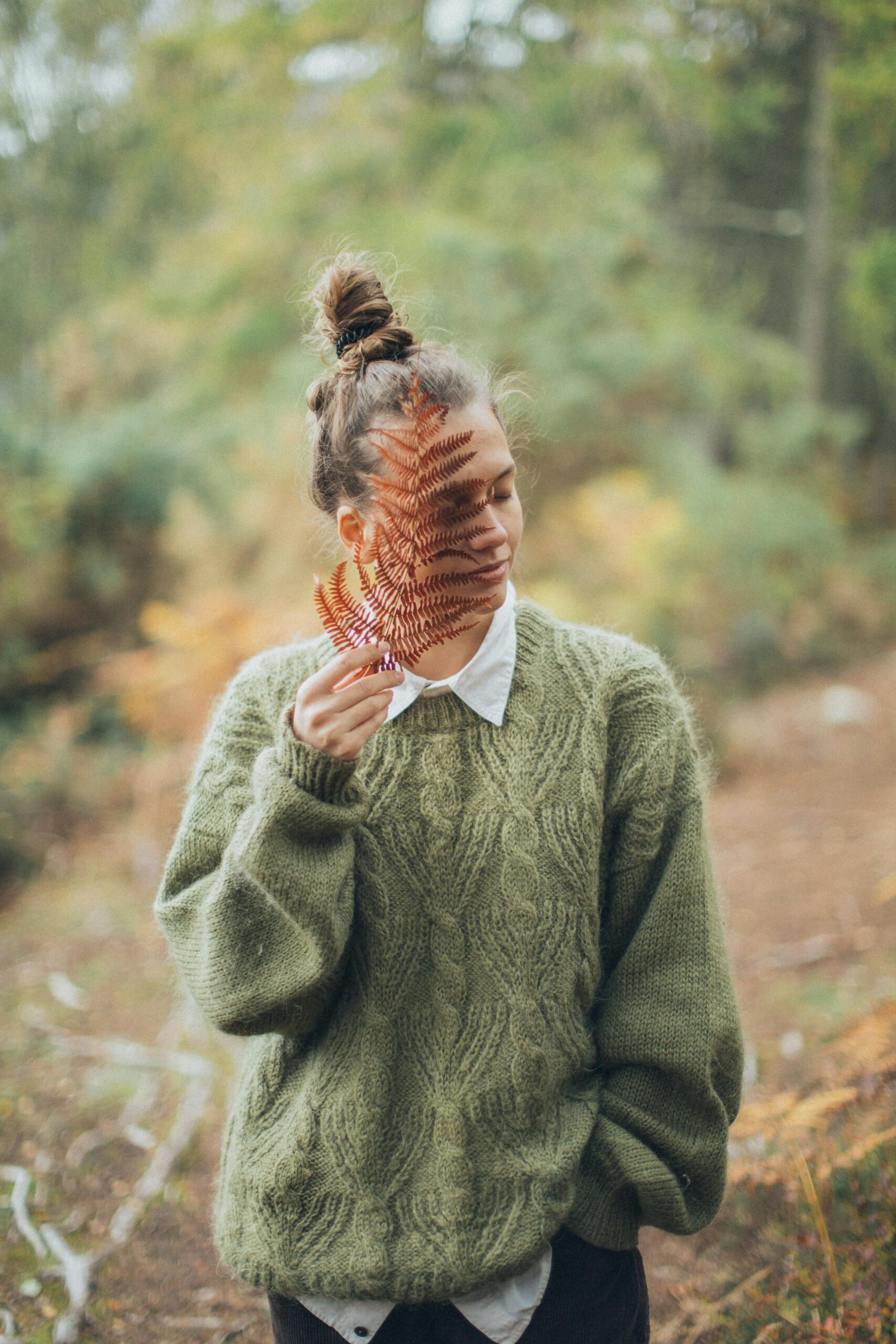 Woman in Nature Sensing Fern as it touches her face